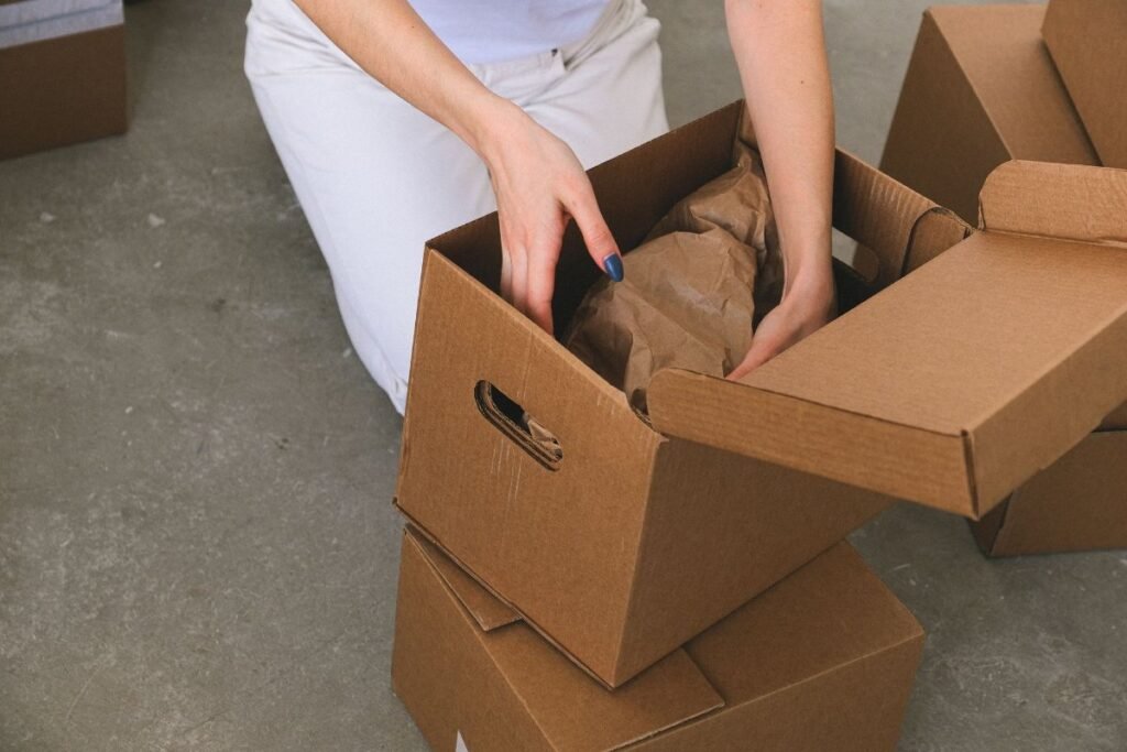 Packing belongings into a cardboard box before a move abroad